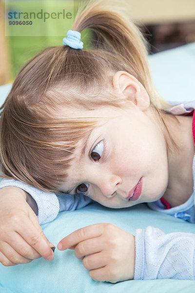 Porträt eines kleinen Mädchens auf einem Bohnensack liegend