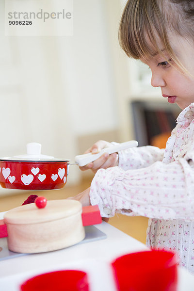Kleines Mädchen spielt mit Kinderküche  Teilansicht