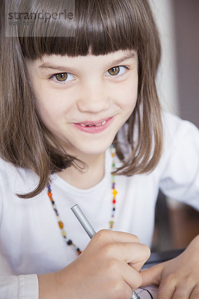 Porträt eines lächelnden kleinen Mädchens mit Wachsmalkreide