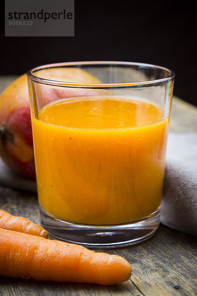 Glass of mango carrot smoothie  carrots and mango