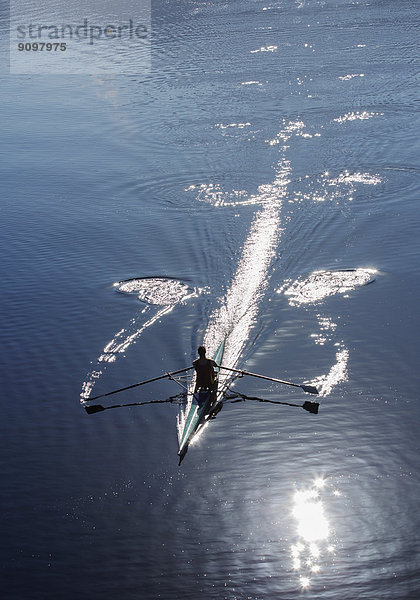 Mann rudert auf dem See