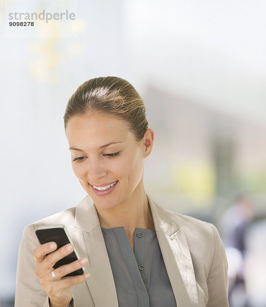 Geschäftsfrau SMS mit Handy im Freien