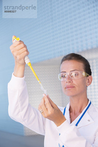 Wissenschaftler mit Pipette und Reagenzglas im Labor