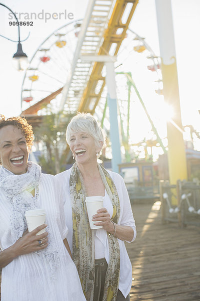 Seniorinnen lachen und trinken Kaffee im Vergnügungspark