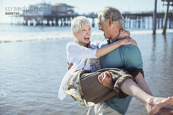 Senior Mann mit Frau am sonnigen Strand