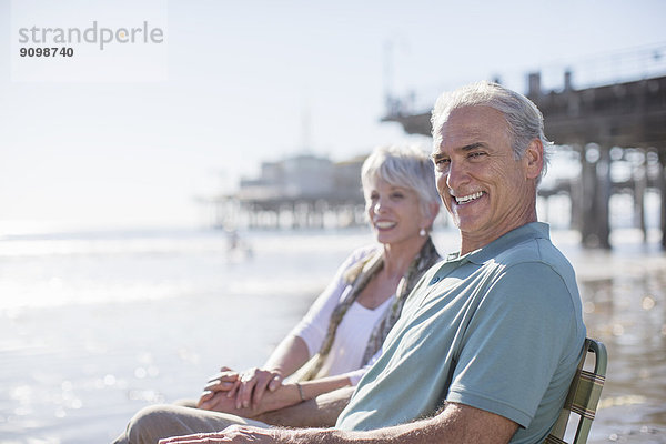 Porträt eines Seniorenpaares am sonnigen Strand