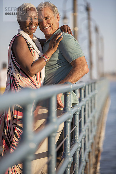 Porträt eines lächelnden Seniorenpaares am Pier