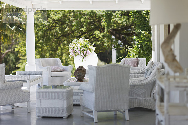 Weiße Korbmöbel auf luxuriöser Terrasse