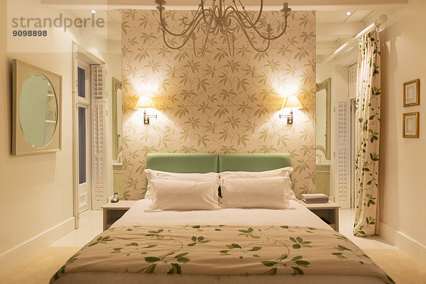 Luxuriöses Schlafzimmer mit beleuchteten Wandleuchten