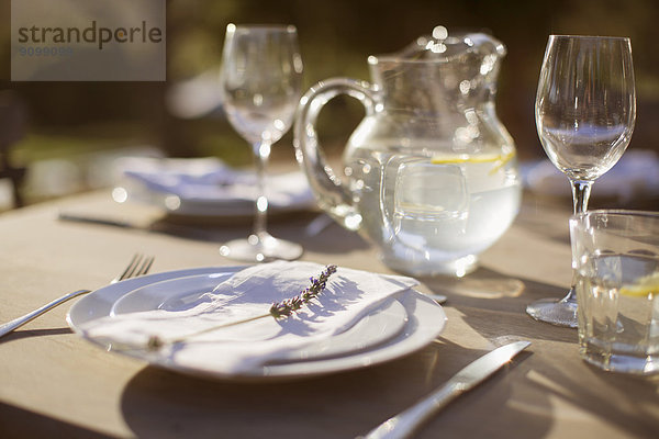 Lavendelzweig auf Teller auf sonnigem Terrassentisch