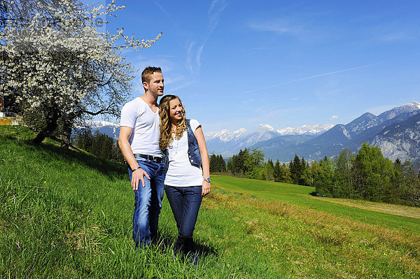Liebespaar im Frühling  hinten ein blühender Baum und Berge  Götzens  Tirol  Österreich
