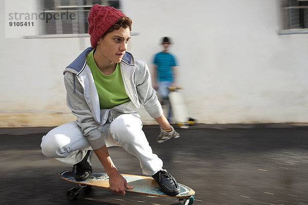 Teenager auf einem Longboard  Skateboard