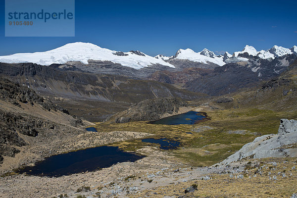Mehrere Bergseen in einem Hochtal  hinten die schneebedeckten Berge des Gebirgszugs Cordillera Raura  Nordperu  Peru
