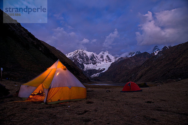Zeltlager am See Laguna Jahuacocha bei Abenddämmerung  hinten schneebedeckte Berge  Gebirgszug Cordillera Huayhuash  Nordperu  Peru