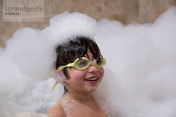 Portrait des Jungen mit Brille im Schaumbad