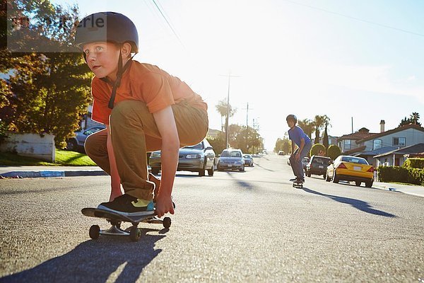 Zwei Jungs beim Skateboarden auf der Vorstadtstraße
