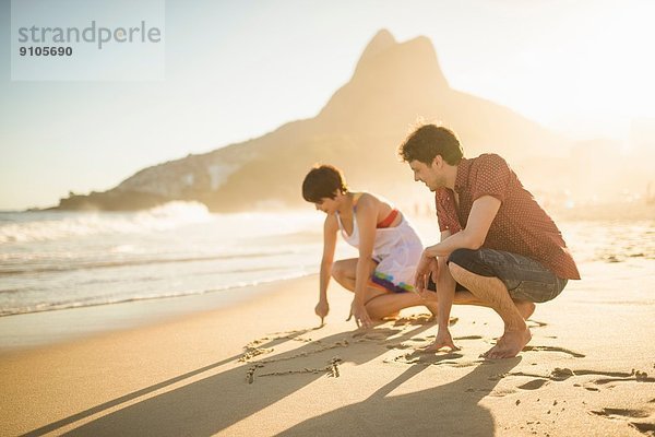 Junges Paar schreibt auf Sand  Ipanema Beach  Rio  Brasilien