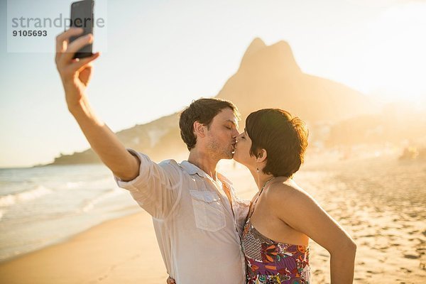 Junges Paar fotografiert sich beim Küssen  Ipanema Beach  Rio  Brasilien