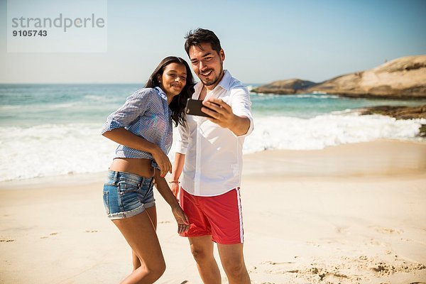 Pärchen nehmen Selfie auf Smartphone  Arpoador Strand  Rio De Janeiro  Brasilien