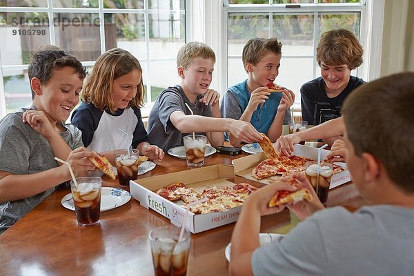 Gruppe von Jungen  die sich eine Pizza teilen