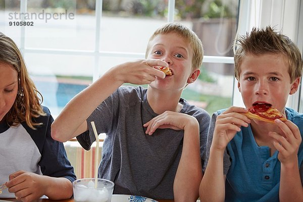 Jungen essen Pizza