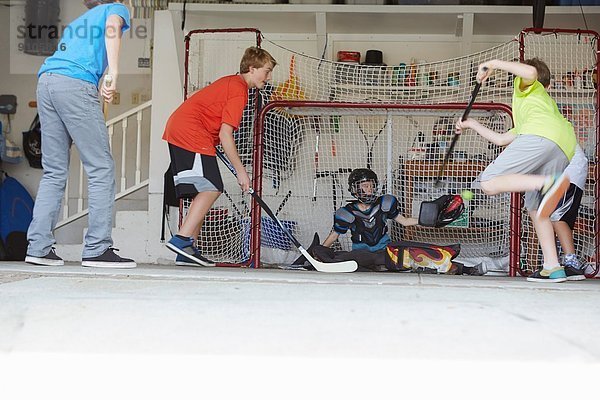 Jungs spielen Hockey in der Garage