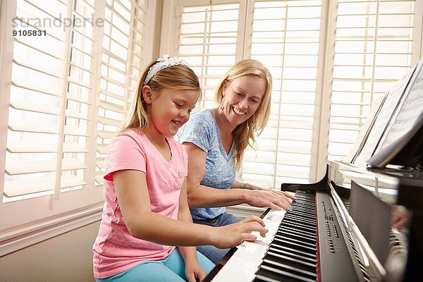 Mutter und Tochter spielen Klavier
