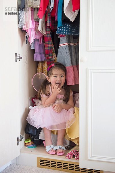 Mädchen in Prinzessin Kostüm versteckt im Schrank
