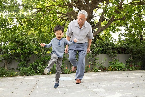 Großvater spielt Hopscotch mit Enkel