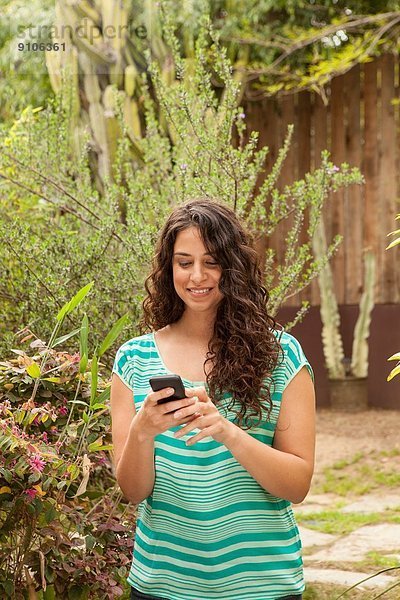 Mädchen im Garten mit Smartphone