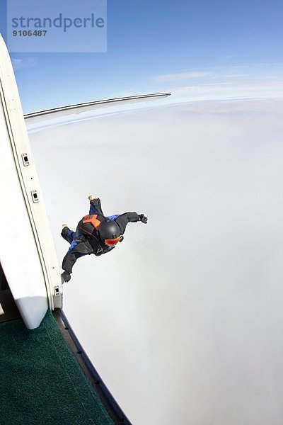 Mittlerer Erwachsener Mann in der Luft  der sich darauf vorbereitet  im Wingsuit zu fliegen.