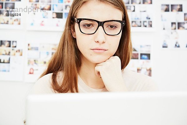 Junge Frau mit Brille am Computer