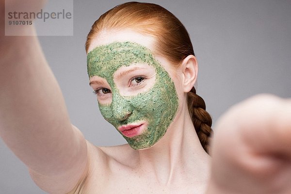 Junge Frau mit Gesichtsmaske  die vor der Kamera schmollt