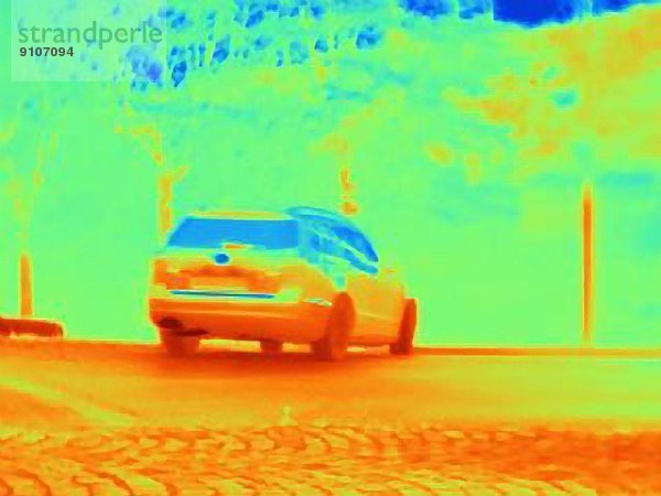 Wärmebild  das die Hitze der Reifen und den Auspuff eines rasenden Autos zeigt