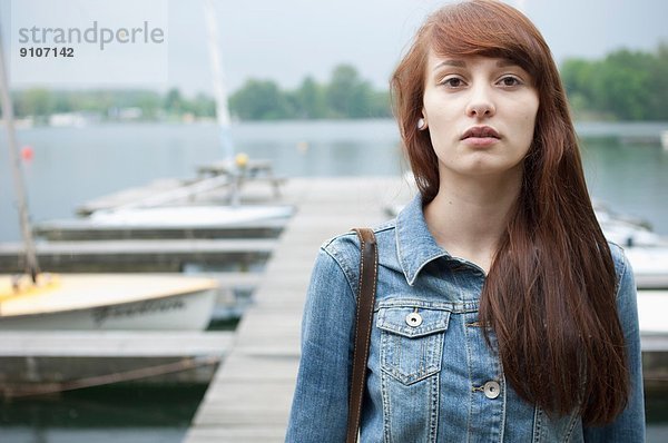 Porträt einer ernsthaften jungen Frau am See