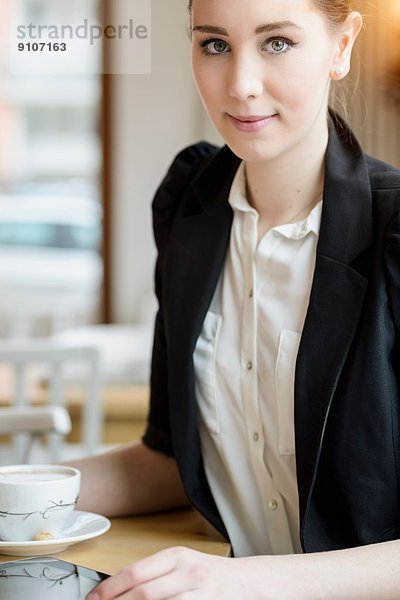 Junge Geschäftsfrau im Café bei einem Kaffee