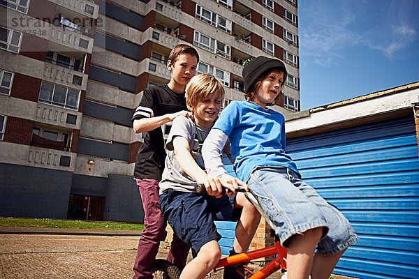 Junge  der zwei Freunde mit dem Fahrrad fährt.
