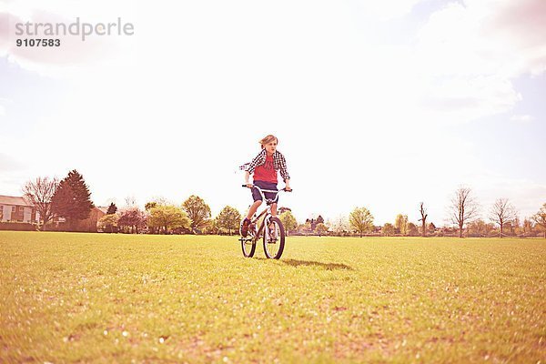 Junge Radfahren auf dem Spielfeld