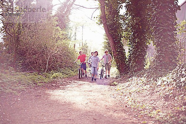 Jungen mit dem Fahrrad auf dem Waldweg