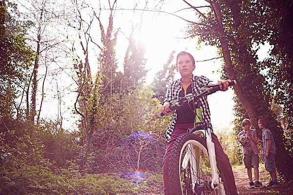 Junge auf dem Fahrrad im Wald