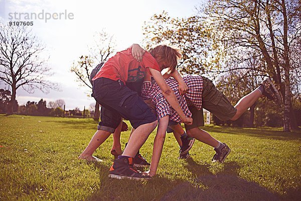 Jungen spielen auf dem Spielfeld.