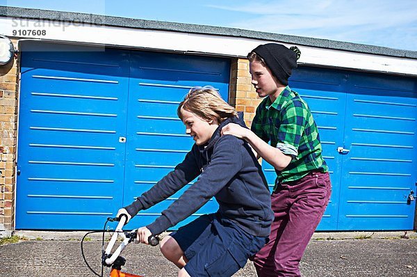 Junge  der einen Freund auf dem Fahrrad mitnimmt