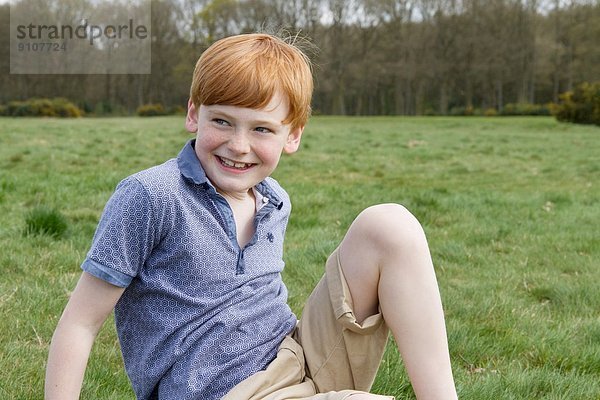 Porträt eines Jungen im Feld sitzend