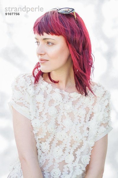 Porträt einer weiblichen jungen Frau mit rosa Haaren