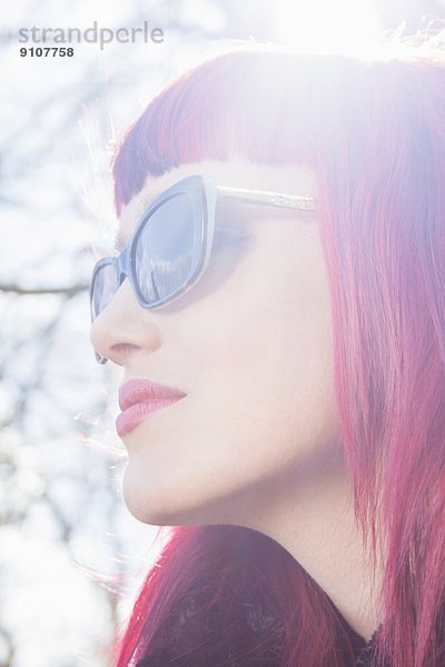 Nahaufnahme Porträt einer jungen Frau mit rosa Haaren und Sonnenbrille