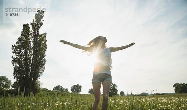 Junge Frau beim Springen im Feld