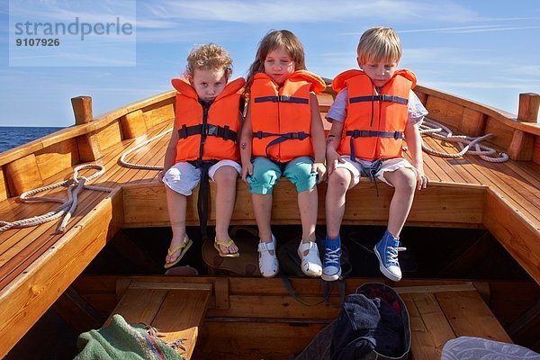 Drei Kinder sitzen im Boot