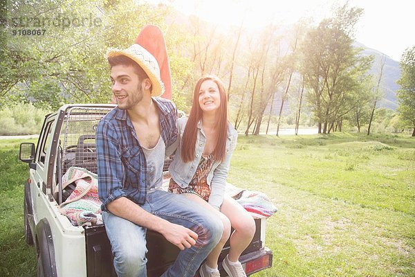 Junges Paar sitzend auf dem Rücken eines Pick-up Trucks  Piemonte  Italien