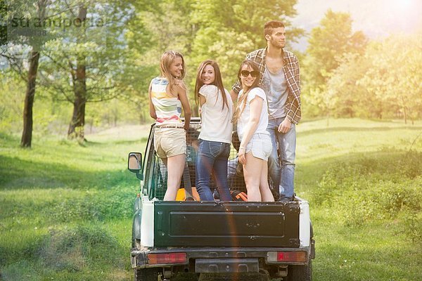 Freunde stehen auf dem Rücksitz des Geländewagens