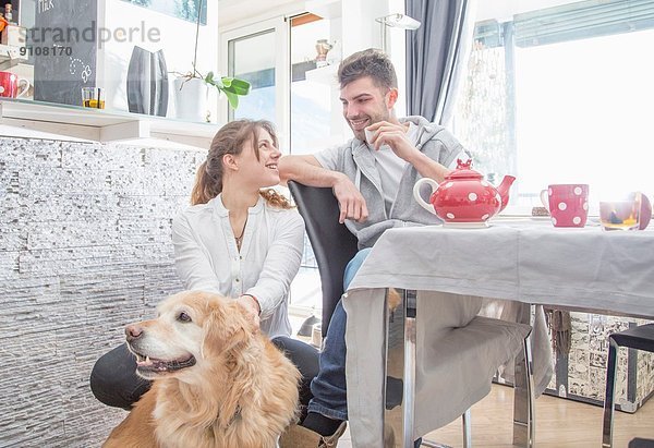 Junges Paar beim Frühstück  mit Hund